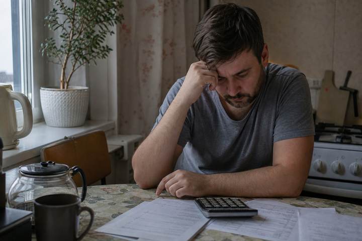Мужчина считает расходы дома